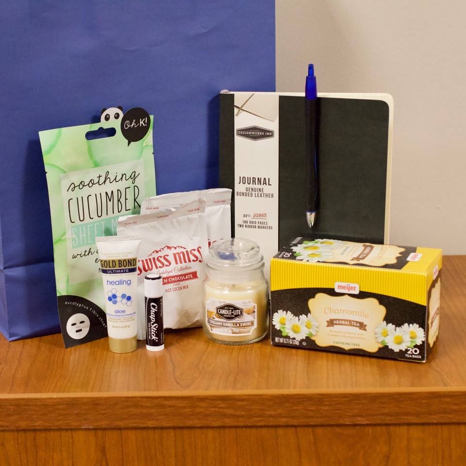 Scavenger hunt prize including a candle, a journal & pen, lotion, Chapstick, hot chocolate, a cleansing face mask and chamomile tea.
